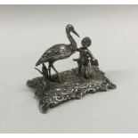 A cast silver table toy in the form of a cherub on