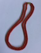 A two row coral necklace of tapering form with gol