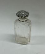 A silver mounted glass scent bottle embossed with