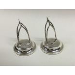 A pair of silver menu holders in the form of wishb