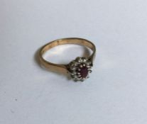 A circular ruby and diamond daisy head cluster rin