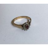 A circular ruby and diamond daisy head cluster rin