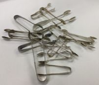 A box containing numerous silver plated sugar tong