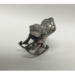 A novelty miniature silver table toy in the form o