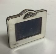 A small rectangular silver picture frame with scro