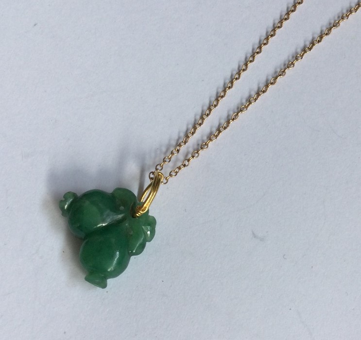 A carved jade pendant on high carat gold chain. Ap