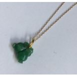 A carved jade pendant on high carat gold chain. Ap