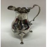 An early Georgian silver cream jug with shaped rim