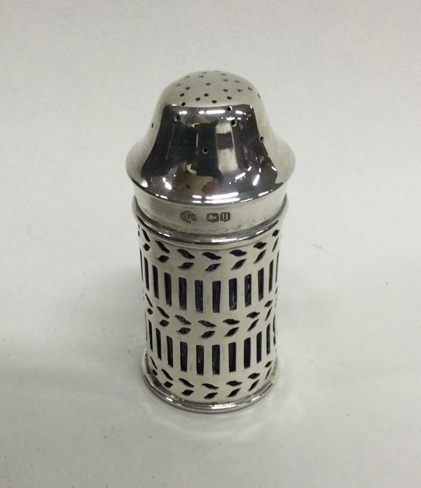 An Edwardian silver pepper with pierced decoration