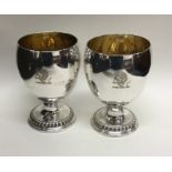 A good pair of Georgian silver goblets with gilt i