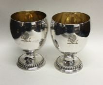 A good pair of Georgian silver goblets with gilt i