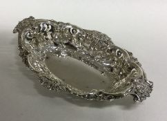 An oval silver pierced bonbon dish with scroll dec