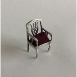 A small silver pin cushion in the form of a chair.