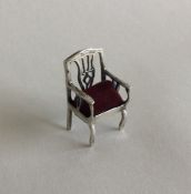 A small silver pin cushion in the form of a chair.