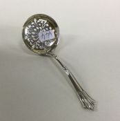 An Edwardian silver sifter spoon with gilt decorat