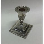 An Edwardian silver candlestick on spreading foot.