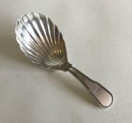 A George III silver fiddle pattern caddy spoon wit