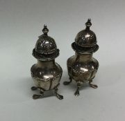 A pair of Edwardian silver peppers on four cabriol