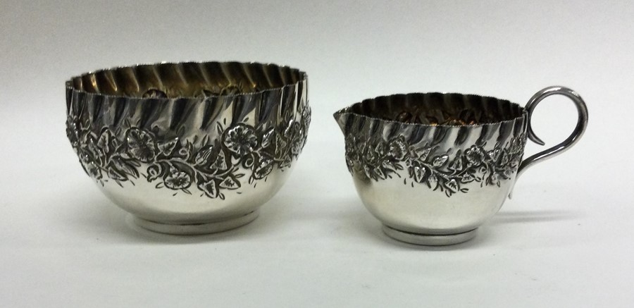 A silver cream jug cast with flowers and leaves. B - Image 2 of 2