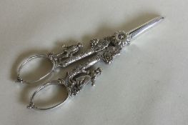 A pair of Edwardian silver grape scissors decorate