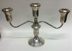 A silver candelabra with scroll decoration. Marked