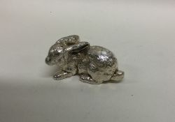 A small silver figure of a rabbit with textured bo