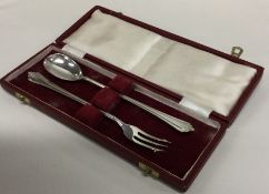 A cased silver pickle fork together with matching