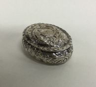 An oval embossed silver box decorated with flowers
