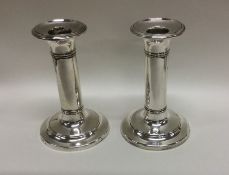 A pair of circular silver candlesticks with reeded