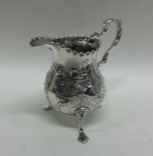 A George III chased silver cream jug. London 1770.