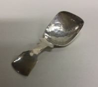 A stylish silver caddy spoon with textured bowl. M