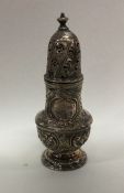 A good heavy chased silver sugar caster decorated