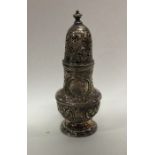 A good heavy chased silver sugar caster decorated