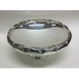 A large circular silver pedestal bowl with crimped