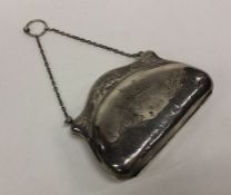 An Edwardian silver purse with floral decoration.