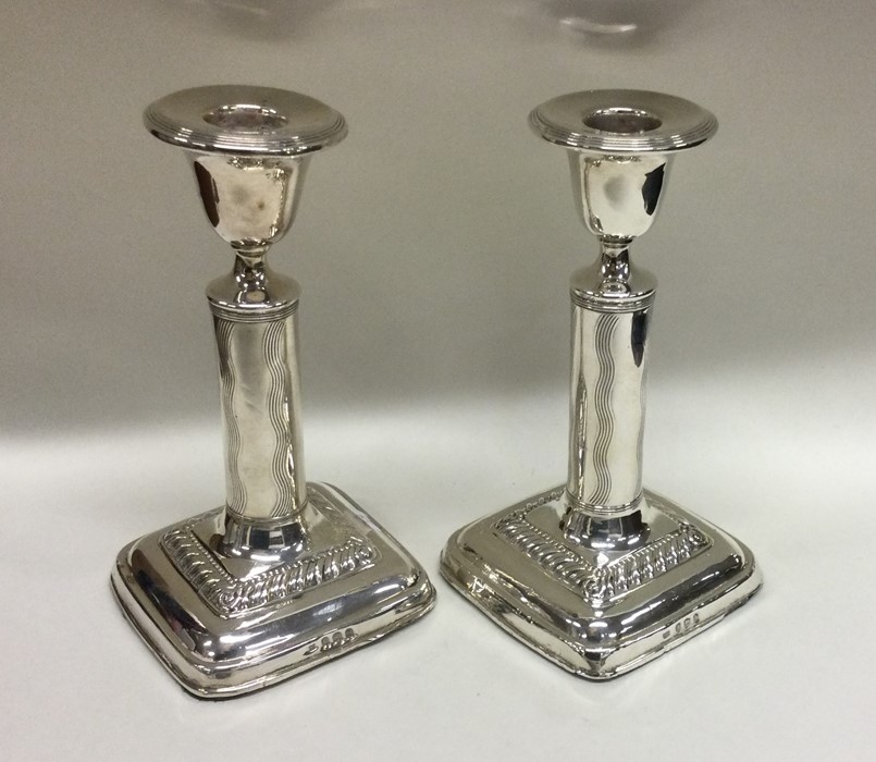 A pair of Edwardian silver candlesticks with reede