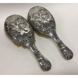 A pair of heavy silver brushes decorated with cher