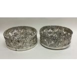 A good pair of Georgian silver coasters profusely