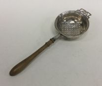 An Edwardian silver tea strainer with turned handl