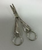 A heavy pair of silver grape scissors decorated wi
