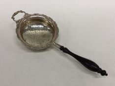 A heavy silver tea strainer with turned handle. Bi