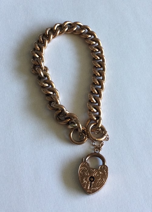 A 9 carat curb bracelet with heart shaped padlock.