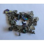 A heavy silver curb link charm bracelet. Approx. 7