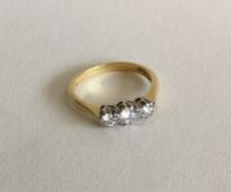 A good diamond three stone ring in two colour gold