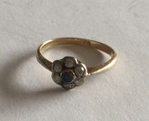 A sapphire and diamond daisy head cluster ring in