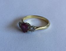 An attractive ruby and diamond three stone ring in