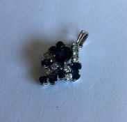 A large sapphire and diamond pendant of stylised f