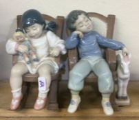 Two Lladro figures of children dozing in a rocking