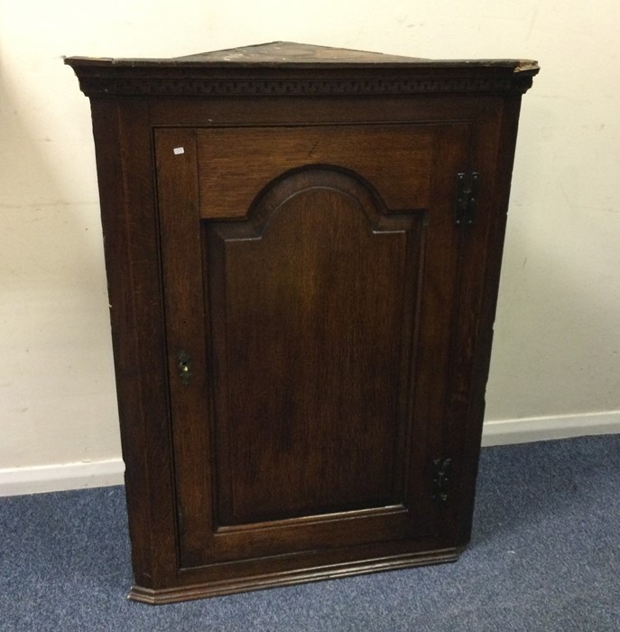 A Georgian oak corner cupboard with arched top. Es