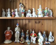 A shelf of decorative porcelain clowns. £15 - £20.